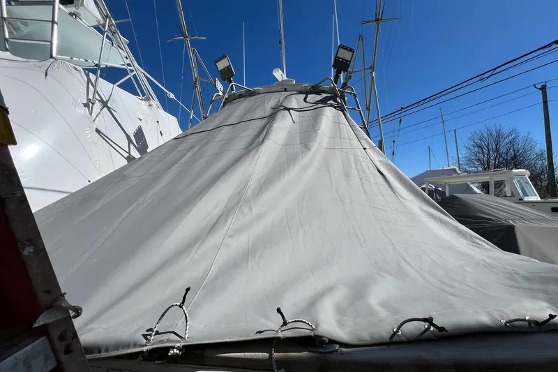 Slide: The Image of Covered 1976 Rare HARRIS 36 EXPRESS boat with clear blue sky background. - 23