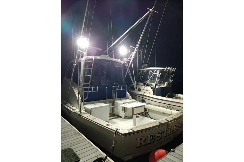 Slide: The Image of 1976 Harris boat docked at night, illuminated by bright lights. - 4