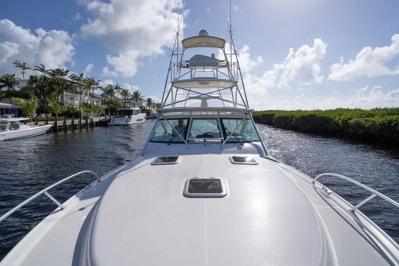 Slide: The Image of 2005 Tiara Yachts 4200 Open cruising on a sunny day, surrounded by lush greenery. - 47