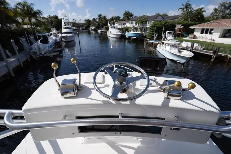 Slide: The Image of Helm of 2005 Tiara Yachts 4200 Open, featuring steering wheel and controls, docked in canal. - 50