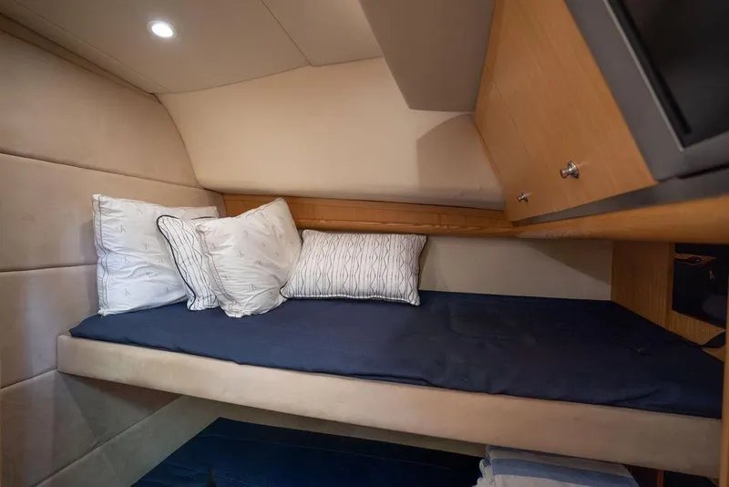 Slide: The Image of Cozy cabin interior of 2005 Tiara Yachts 4200 Open with plush bedding and wooden cabinetry. - 52