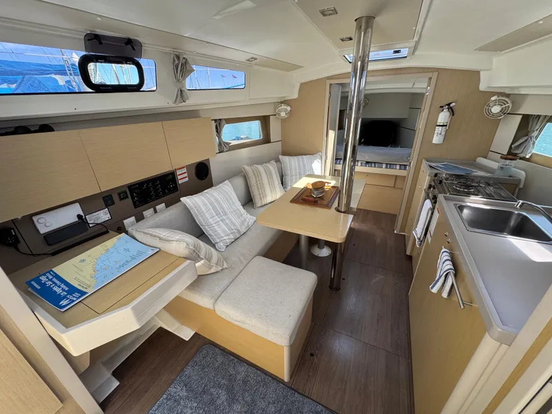 Slide: The Image of Interior of 2021 Beneteau Oceanis 35.1 yacht, featuring cozy seating and modern kitchen amenities. - 10