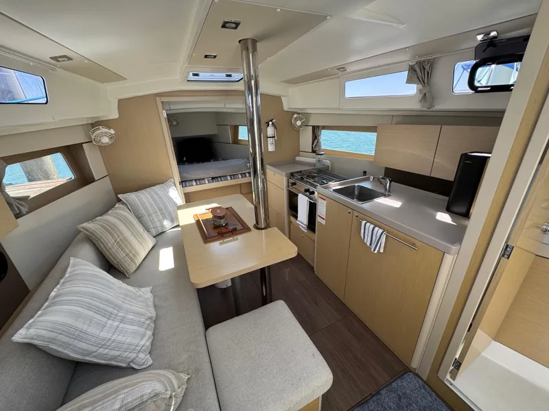 Slide: The Image of Interior of 2021 Beneteau Oceanis 35.1 yacht, featuring modern kitchen and cozy seating area. - 12