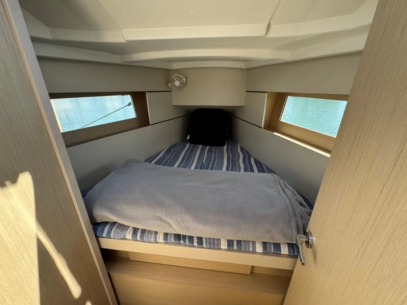 Slide: The Image of Cozy cabin interior of 2021 Beneteau Oceanis 35.1 sailboat with striped bedding. - 15