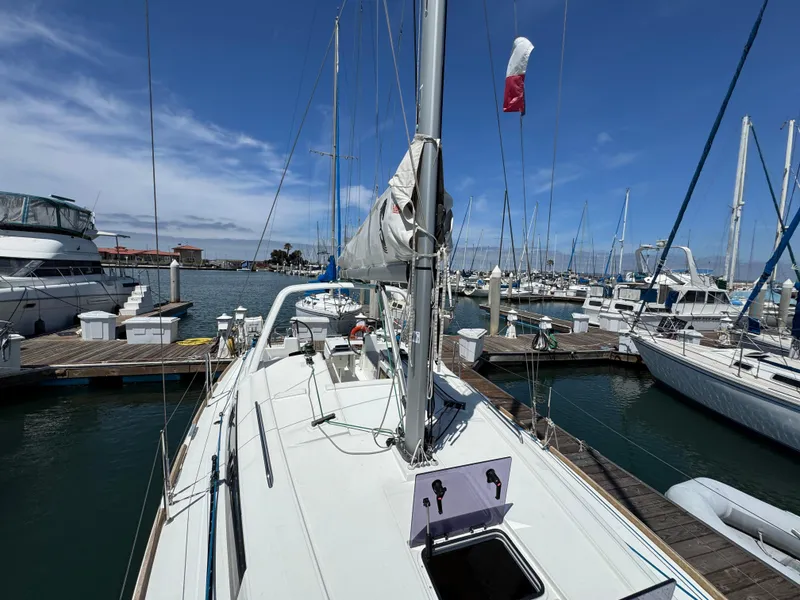 Slide: The Image of 2021 Beneteau Oceanis 35.1 sailboat docked at a marina under a clear blue sky. - 21