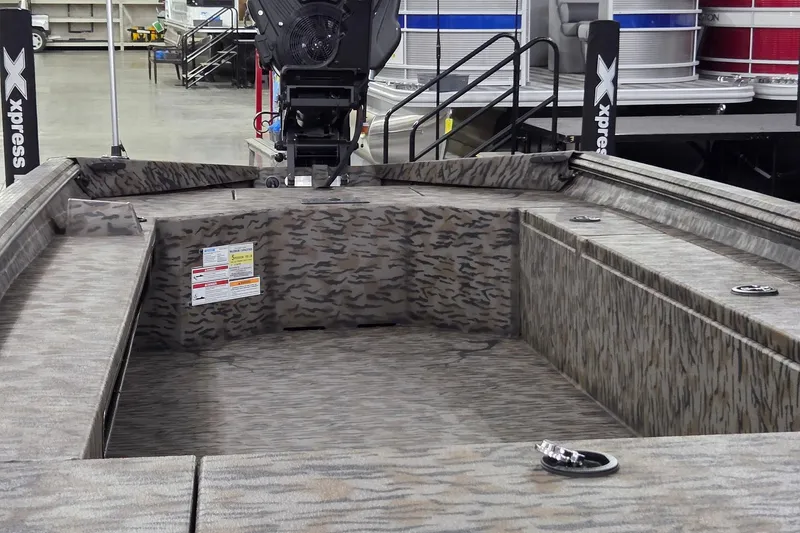 Slide: The Image of 2026 Xpress Bayou 180 boat interior with camouflage design, featuring a motor and storage compartments. - 3