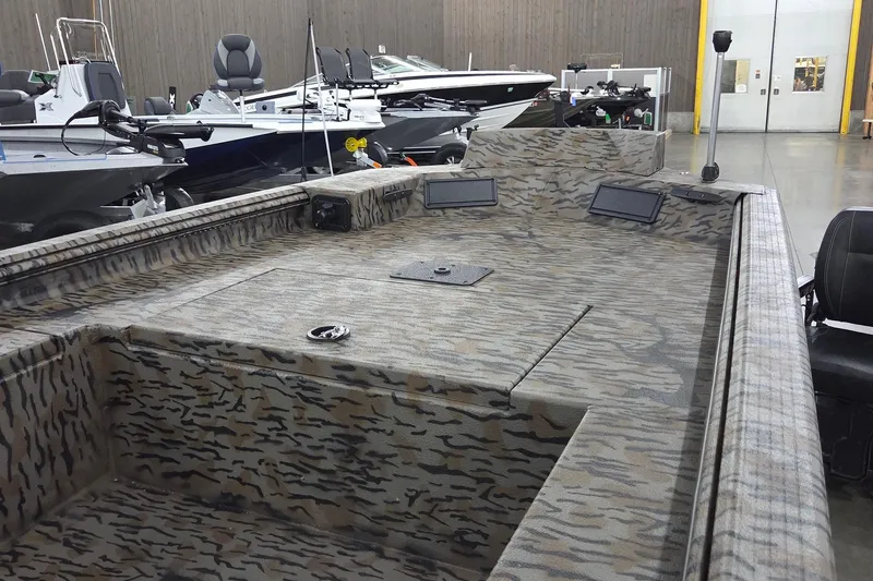Slide: The Image of 2026 Xpress Bayou 180 boat interior with camouflage design in showroom setting. - 4