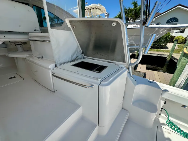 Slide: The Image of 2018 Tiara Yachts 4300 Open cockpit with open storage compartment and sleek white design. - 13