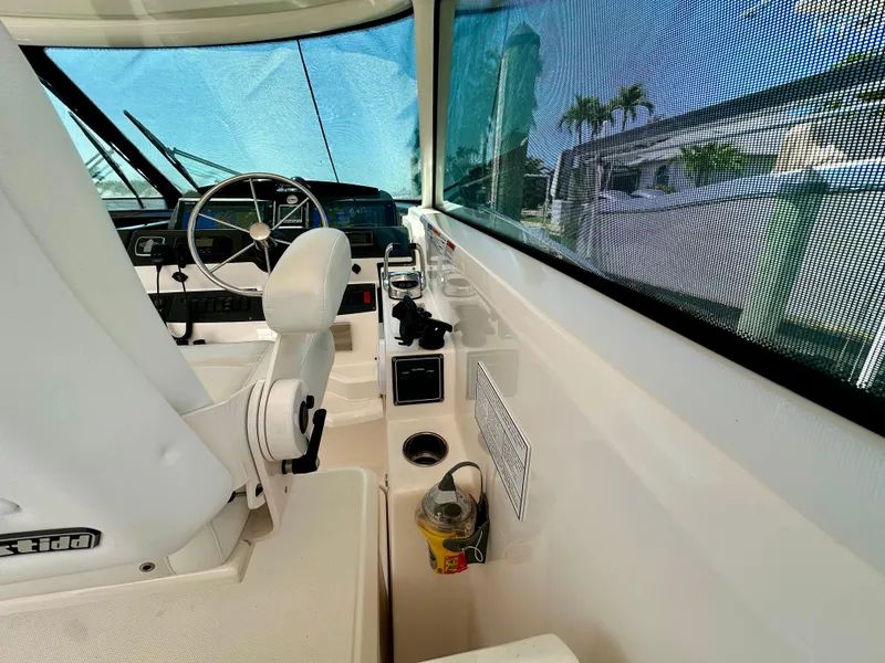 Slide: The Image of 2018 Tiara Yachts 4300 Open helm with steering wheel and controls, featuring a sleek design. - 17