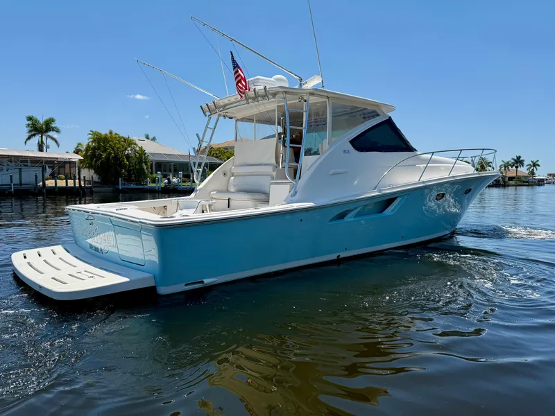 Slide: The Image of 2018 Tiara Yachts 4300 Open cruising on a sunny day, featuring sleek design and vibrant blue hull. - 2