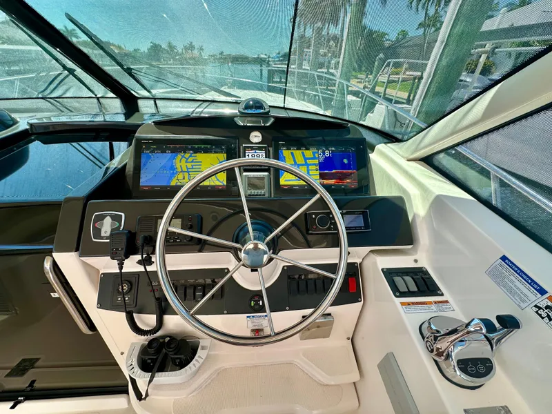 Slide: The Image of 2018 Tiara Yachts 4300 Open helm with navigation screens and steering wheel. - 20