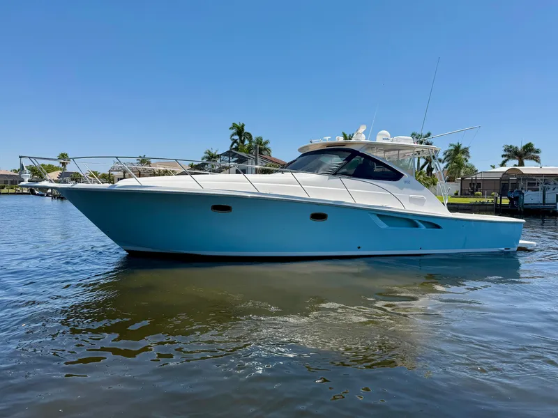 Slide: The Image of 2018 Tiara Yachts 4300 Open cruising on a sunny day, surrounded by calm waters and palm trees. - 3