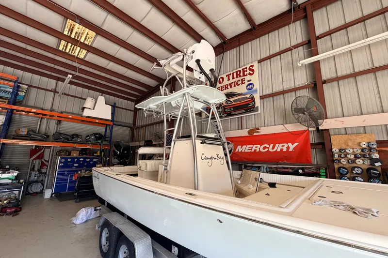 Slide: The Image of 2010 Canyon Bay 24H boat in a garage with Mercury signage. - 100