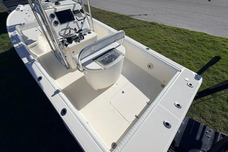 Slide: The Image of 2010 Canyon Bay 24H boat interior with steering console and seating on grassy area. - 13