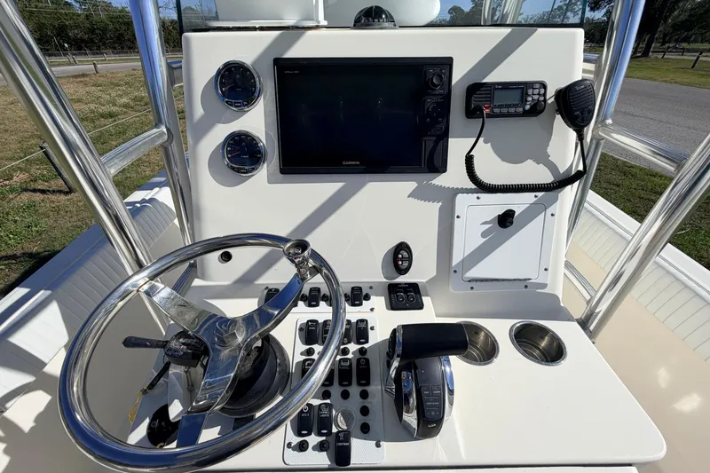 Slide: The Image of Control panel of a 2010 Canyon Bay 24H boat with steering wheel and navigation instruments. - 28