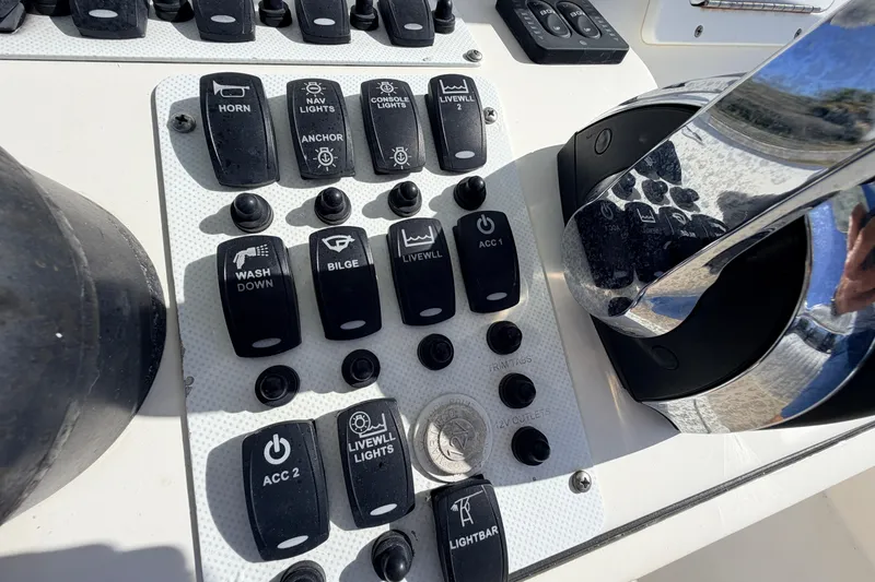 Slide: The Image of Control panel of a 2010 Canyon Bay 24H boat with various switches and buttons. - 35