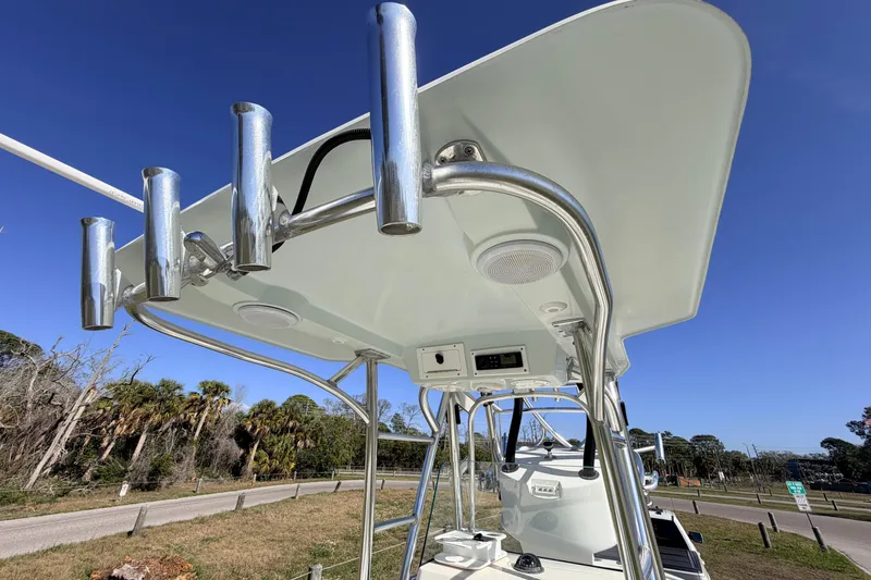 Slide: The Image of 2010 Canyon Bay 24H boat with T-top and rod holders under clear blue sky. - 46
