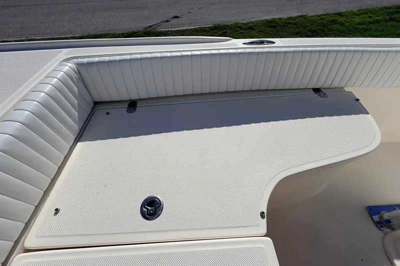 Slide: The Image of Canyon Bay 24H 2010 boat interior with white cushioned seating and storage compartment. - 62