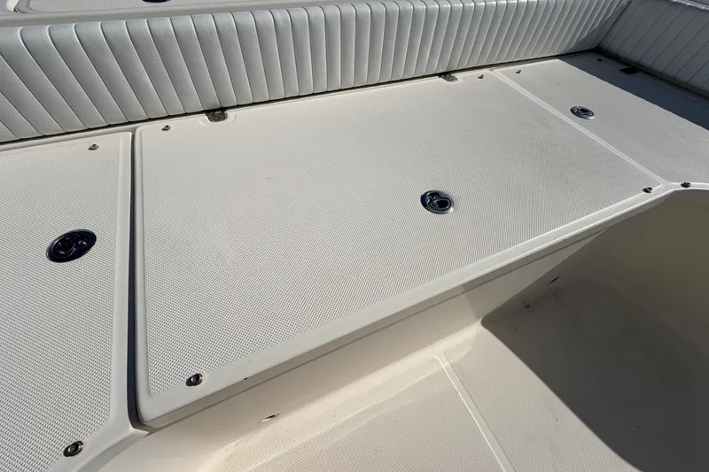 Slide: The Image of 2010 Canyon Bay 24H boat deck with cushioned seating and storage compartments. - 65