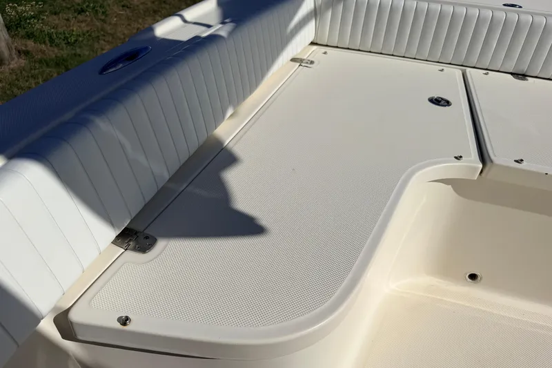 Slide: The Image of Canyon Bay 24H 2010 boat interior with white cushioned seating and storage compartments. - 68