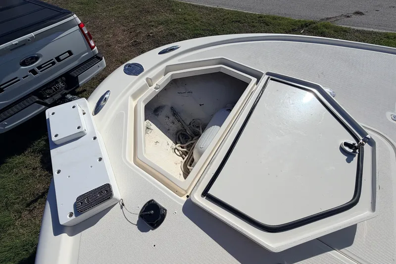 Slide: The Image of Open storage compartment on 2010 Canyon Bay 24H boat, parked beside a Ford F-150. - 77