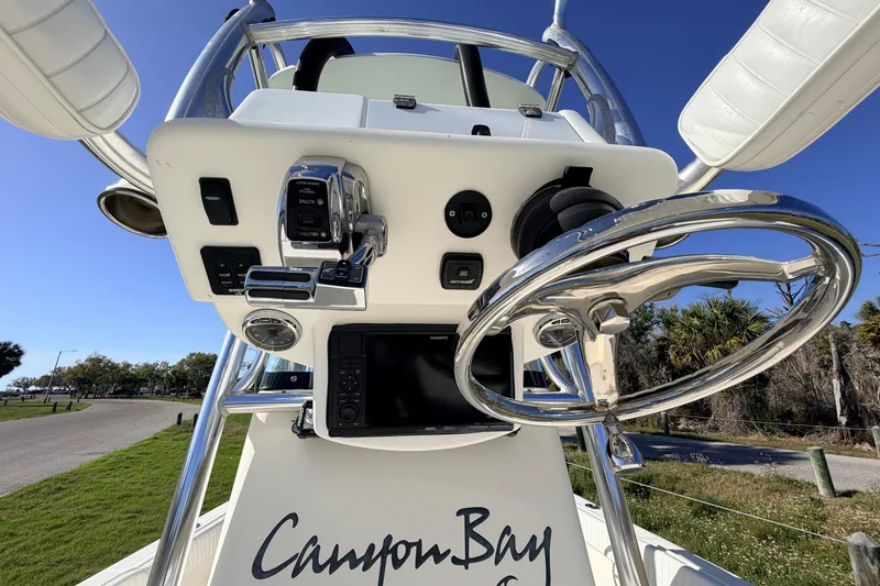 Slide: The Image of Steering console of a 2010 Canyon Bay 24H boat with controls and navigation equipment. - 79