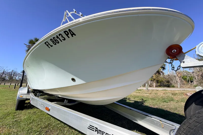 Slide: The Image of 2010 Canyon Bay 24H boat on trailer, grassy area, clear blue sky. - 92