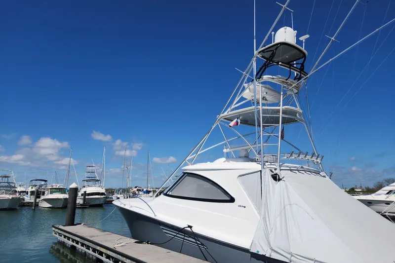 Slide: The Image of 2018 Viking 48 Sport Tower yacht docked in a marina under clear blue skies. - 1