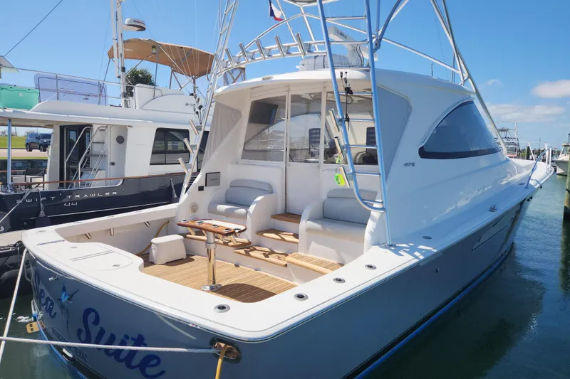 Slide: The Image of 2018 Viking 48 Sport Tower yacht docked, featuring spacious deck and sleek design. - 100