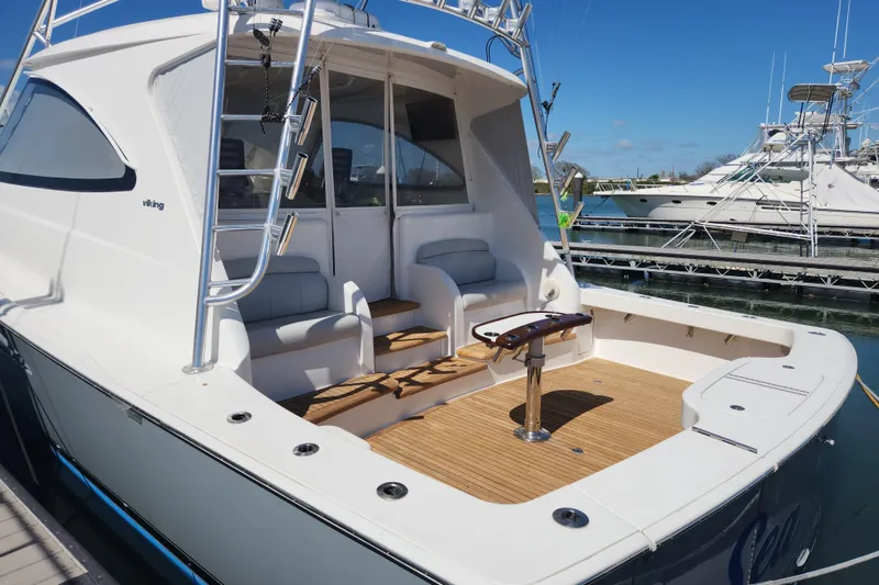 Slide: The Image of 2018 Viking 48 Sport Tower yacht with spacious deck and seating at marina. - 101