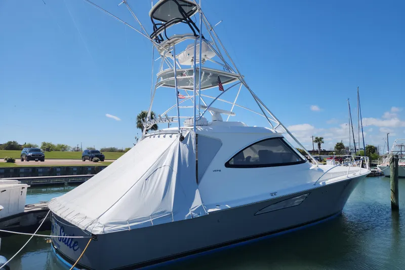 Slide: The Image of 2018 Viking 48 Sport Tower yacht docked in a marina under clear blue skies. - 11