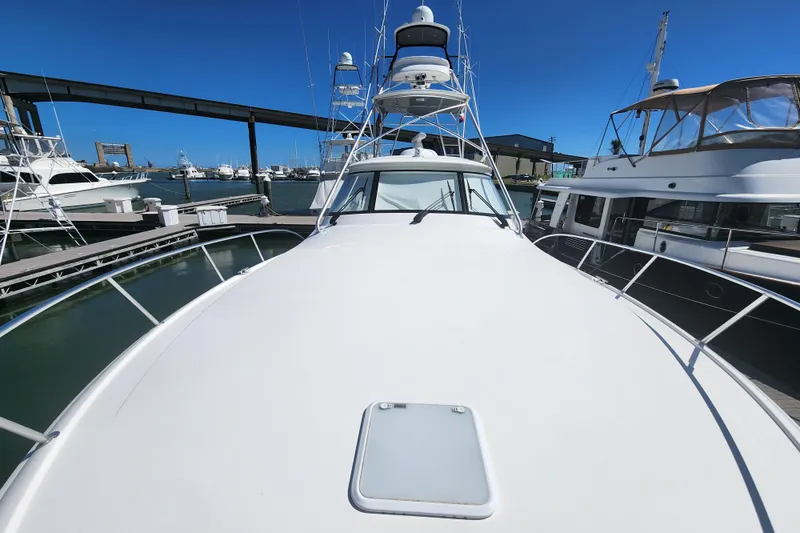 Slide: The Image of 2018 Viking 48 Sport Tower yacht docked at marina under clear blue sky. - 111