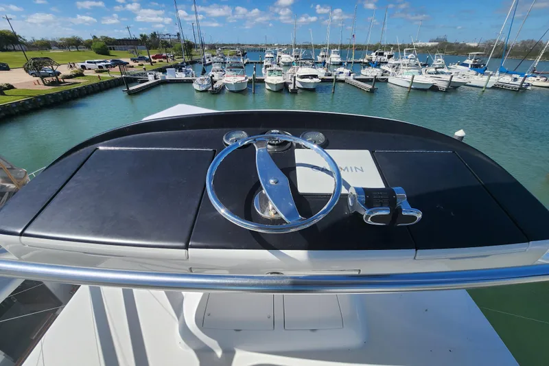 Slide: The Image of Helm of 2018 Viking 48 Sport Tower overlooking marina with boats docked. - 114