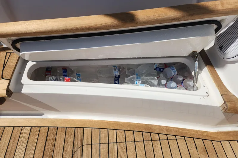 Slide: The Image of Built-in cooler with water bottles on 2018 Viking 48 Sport Tower yacht deck. - 120