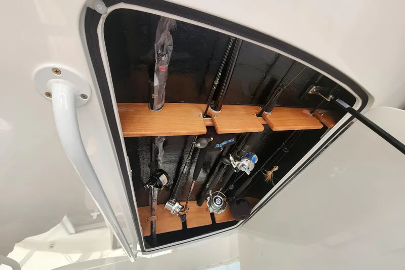 Slide: The Image of Fishing rod storage on 2018 Viking 48 Sport Tower boat, featuring organized wooden racks. - 124