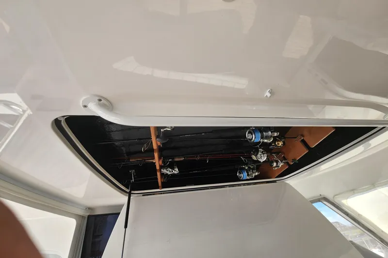Slide: The Image of Interior view of 2018 Viking 48 Sport Tower with fishing rods stored overhead. - 129