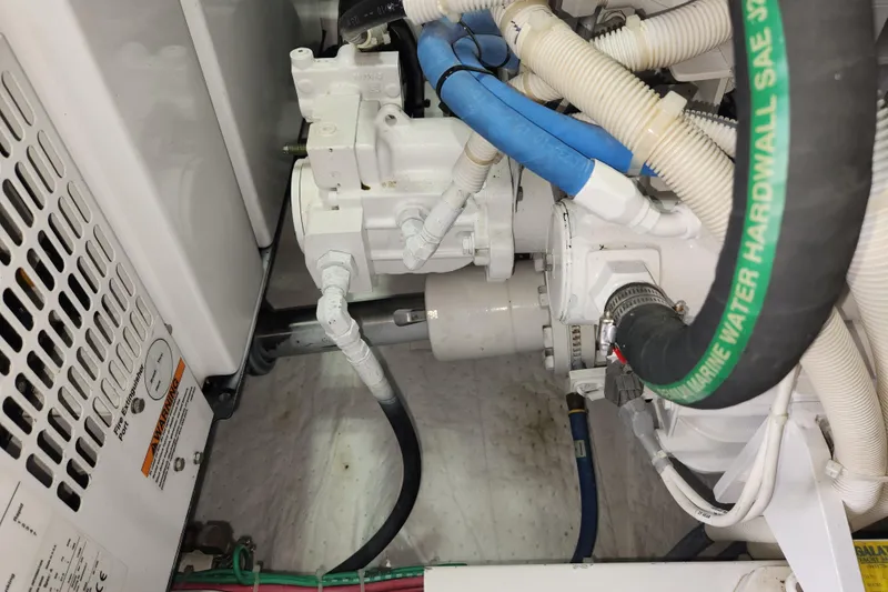 Slide: The Image of Engine compartment of a 2018 Viking 48 Sport Tower with hoses and mechanical components. - 140