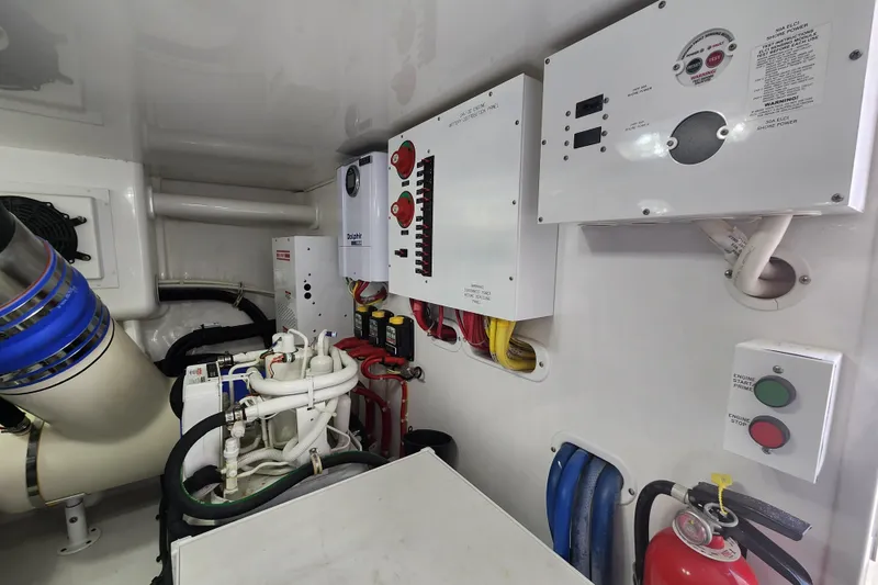 Slide: The Image of Engine room of 2018 Viking 48 Sport Tower with control panels and fire extinguisher. - 146
