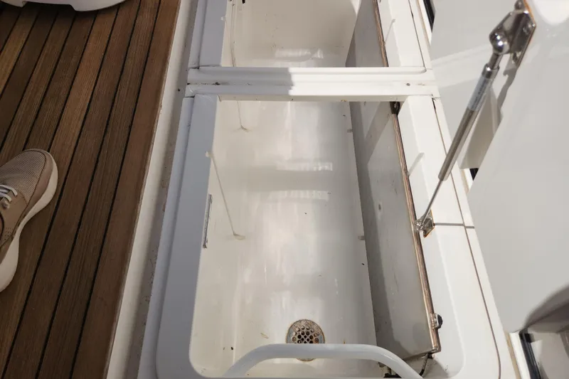 Slide: The Image of Open storage compartment on 2018 Viking 48 Sport Tower boat with wooden deck. - 167