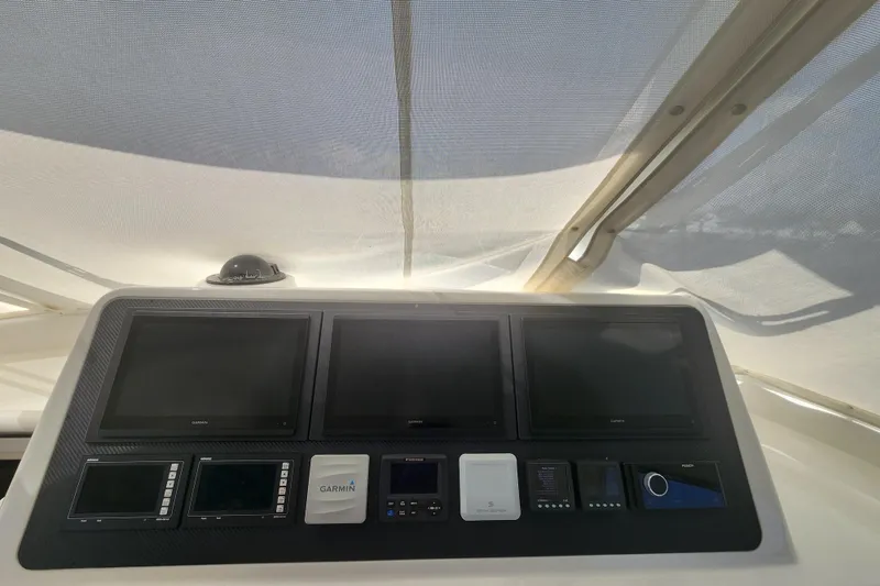 Slide: The Image of Control panel of 2018 Viking 48 Sport Tower with multiple screens and navigation equipment. - 17