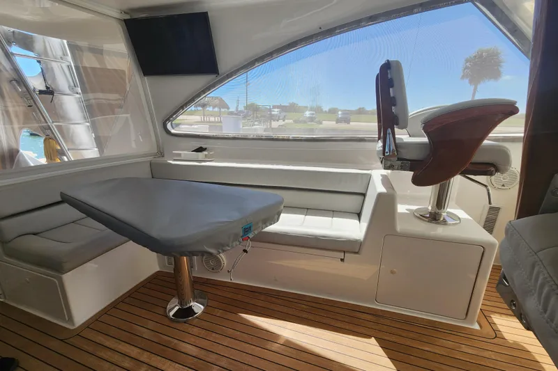 Slide: The Image of Interior of 2018 Viking 48 Sport Tower with seating, table, and helm chair. - 27