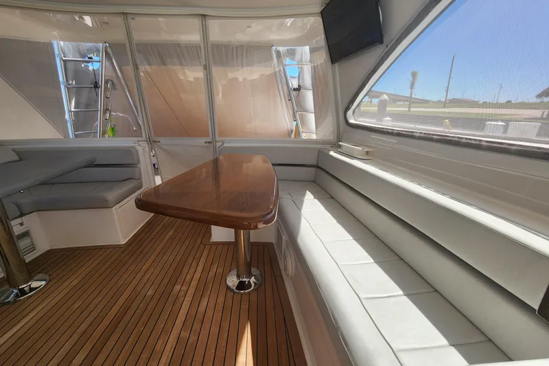Slide: The Image of Luxurious interior of 2018 Viking 48 Sport Tower with wooden table and seating. - 28