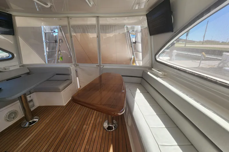 Slide: The Image of Luxurious interior of 2018 Viking 48 Sport Tower with wooden table and plush seating. - 29