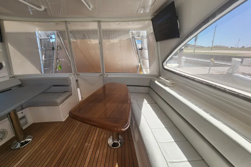 Slide: The Image of Luxurious interior of 2018 Viking 48 Sport Tower yacht with wooden table and seating. - 30