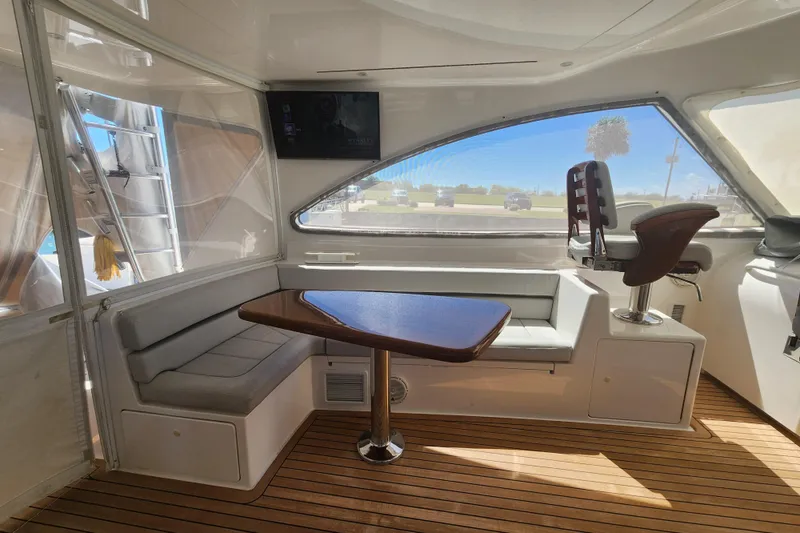 Slide: The Image of Interior of 2018 Viking 48 Sport Tower with seating, table, and wooden flooring. - 43