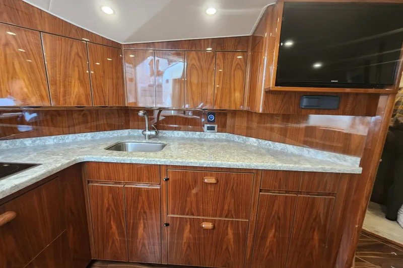 Slide: The Image of Luxurious wood-finished kitchen in 2018 Viking 48 Sport Tower yacht with modern amenities. - 49