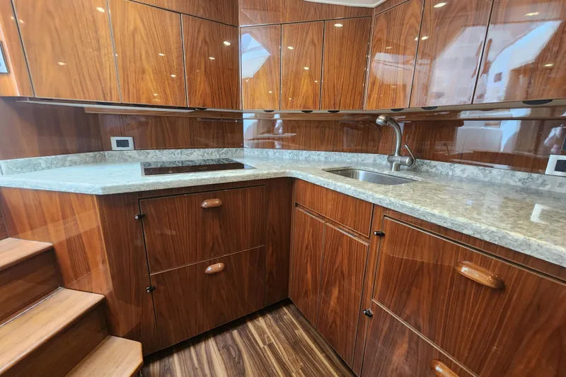 Slide: The Image of Luxurious wood-paneled kitchen in 2018 Viking 48 Sport Tower yacht with granite countertops. - 51