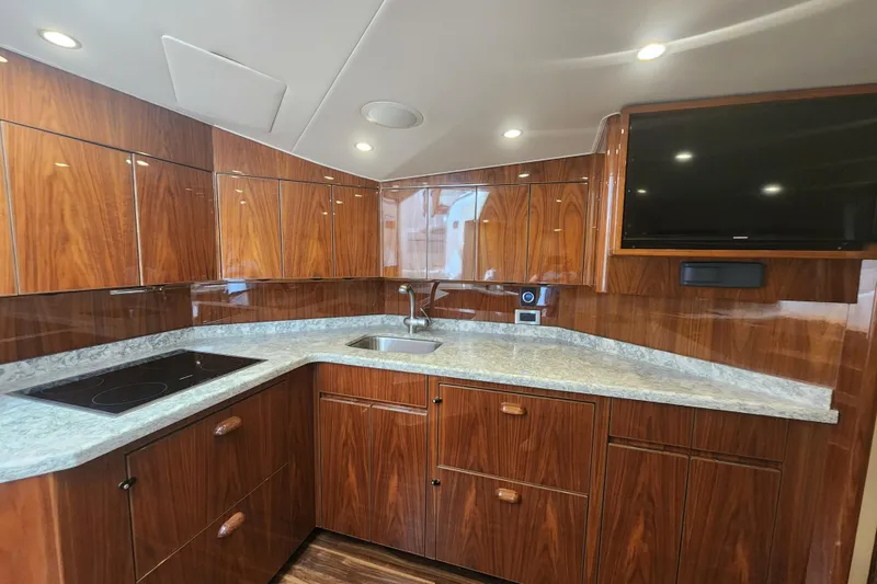 Slide: The Image of Luxurious kitchen interior of 2018 Viking 48 Sport Tower yacht with wood cabinetry and modern appliances. - 54