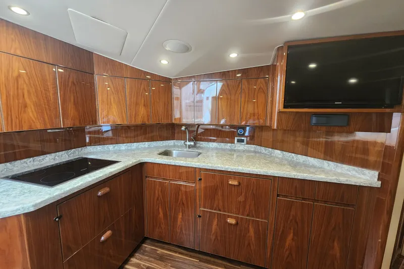 Slide: The Image of Luxurious kitchen interior of 2018 Viking 48 Sport Tower yacht with wood cabinetry and modern appliances. - 55