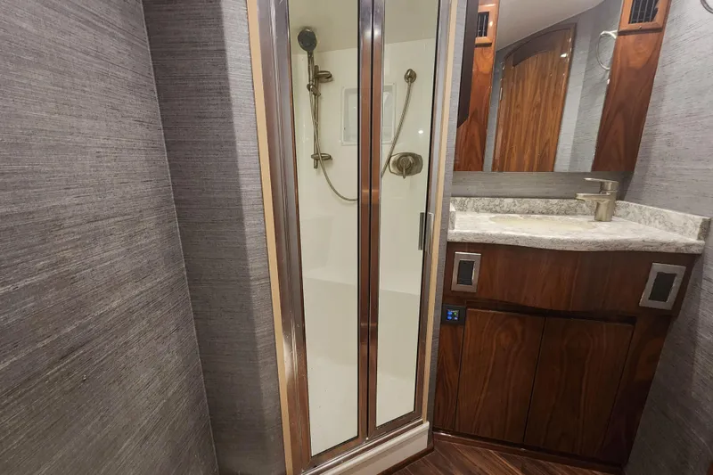 Slide: The Image of Luxurious bathroom in 2018 Viking 48 Sport Tower yacht with shower and wooden cabinetry. - 64